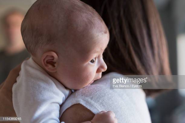 side-view-of-woman-holding-daughter-at-home-picture-id1154369245
